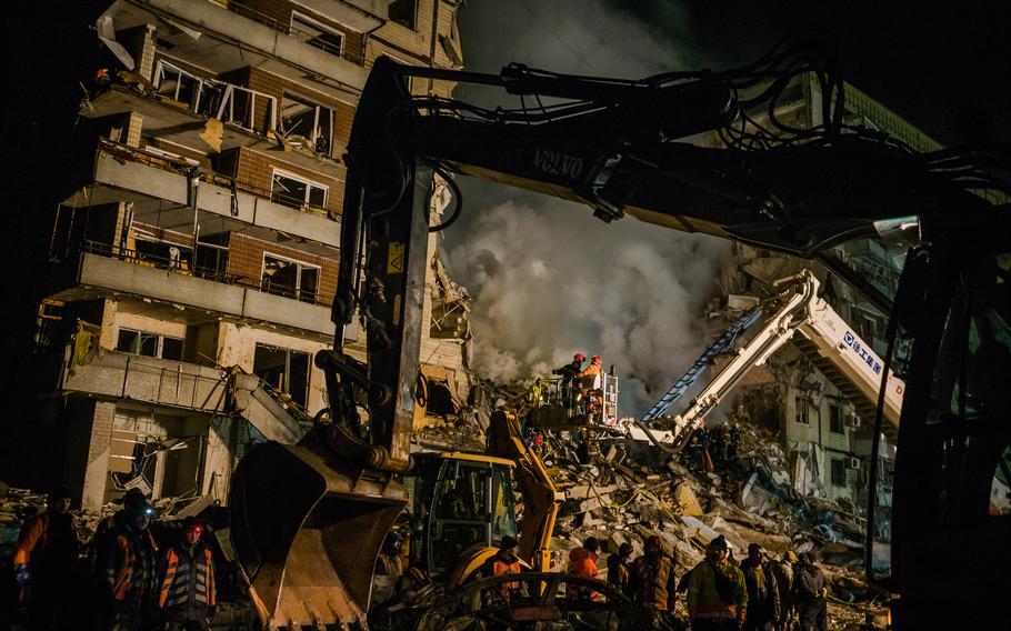 Rescuers work to free victims from the rubble of a residential apartment complex that was hit by Russian forces in Dnipro, Ukraine, on January 14, 2023. Several people were killed and more than 25 were injured, including children. The attack marked the most significant strike on the central Ukrainian city since the war began. Dnipro had until now served as a safe haven for thousands of displaced people from other regions. 