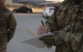 A uniformed troop writes in a notebook.