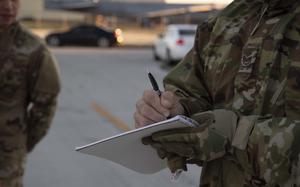 A uniformed troop writes in a notebook.