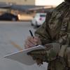 A uniformed troop writes in a notebook.