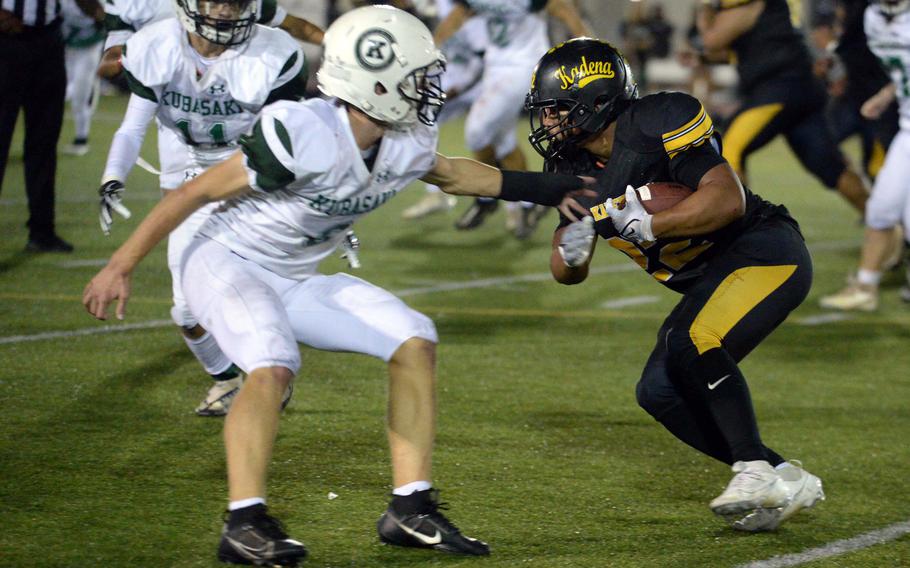 Kubasaki's Caleb Stephan tries to reel in Kadena running back Jeremiah Drummer.