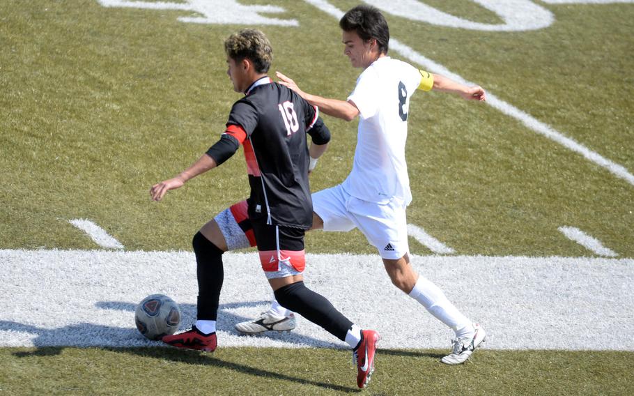 E.J. King's Damian Perez dribbles against Kadena's Tuck Renquist during Saturday's DODEA interdistrict boys soccer match. The Panthers won 1-0.