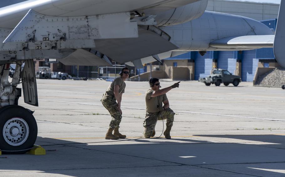 Airmen point under an aircraft
