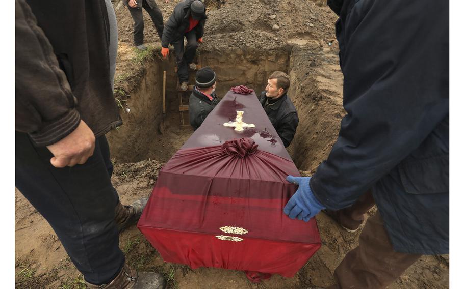Three members of the Ostrovskii family including Viktorya ,51, Anatoli, 75, and Vyacheslav, 32, were buried together in a single grave at the Bucha cemetery on April 22, 2022. The three were shot and killed by Russians on March 7, as they tried to flee Bucha, Ukraine, in their car according to a family friend who was there to oversee their burial. 