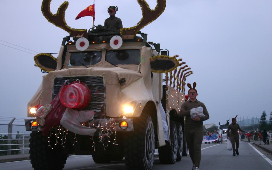 Marines of Headquarters Company, Combat Logistics Regiment 37, throw candy from their “Grandma Got Run Over by a Reindeer” float during the Camp Kinser, Okinawa, Christmas parade, Dec. 7, 2007. Sgt. Cody Perry said the float was his idea and it took the unit about three weeks to turn the up-armored 7-ton truck into a reindeer. “It was definitely worth it,” he said. The float won third place. 