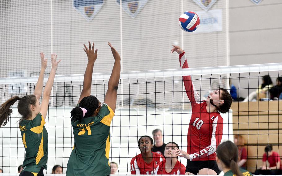 Kaiserslautern middle hitter Mariska Campbell hits the ball while SHAPE's Zeynep Telefoncu, left, and Kayla Mckinney go up to block during a scrimmage at Ramstein High School on Ramstein Air Base, Germany, on Sept. 1, 2023.