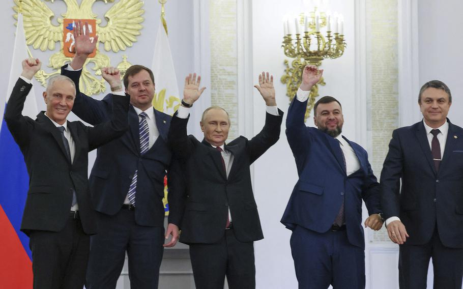From left: Moscow-appointed heads of the Kherson region, Vladimir Saldo, and of the  Zaporizhzhia region, Yevgeny Balitsky;  Russian President Vladimir Putin, center; Donetsk separatist leader Denis Pushilin and Lugansk separatist leader Leonid Pasechnik celebrate at the Kremlin in Moscow on Friday, September 30, 2022, after signing treaties formally annexing four regions of Ukraine that Russian troops occupy. 