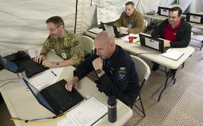U.S. and foreign military personnel participate in a computer network demonstration in Suffolk, Va., in 2011. The network allows the U.S. and partners to share low-level classified information. A research report released in March says that a lot of information is being needlessly classified, which may hurt collaboration with partner forces.