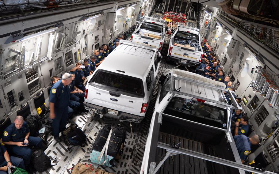 Honolulu Fire Department vehicles and personnel are secured onto a C-17 Globemaster III Aug. 10, 2023, at Joint Base Pearl Harbor-Hickam, Hawaii. A Hawaii Air National Guard aircrew from the 204th Airlift Squadron transported a team comprised of firefighters, rescue specialists and incident management personnel, and disaster-relief cargo to aid communities impacted by several wildfires.