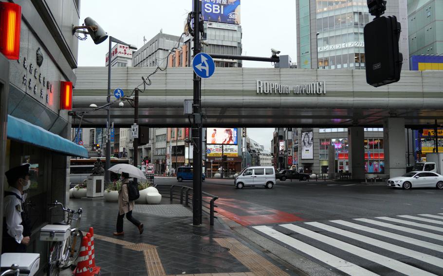 A policeman watches over Roppongi Crossing in central Tokyo, Friday, Oct. 22, 2021. 