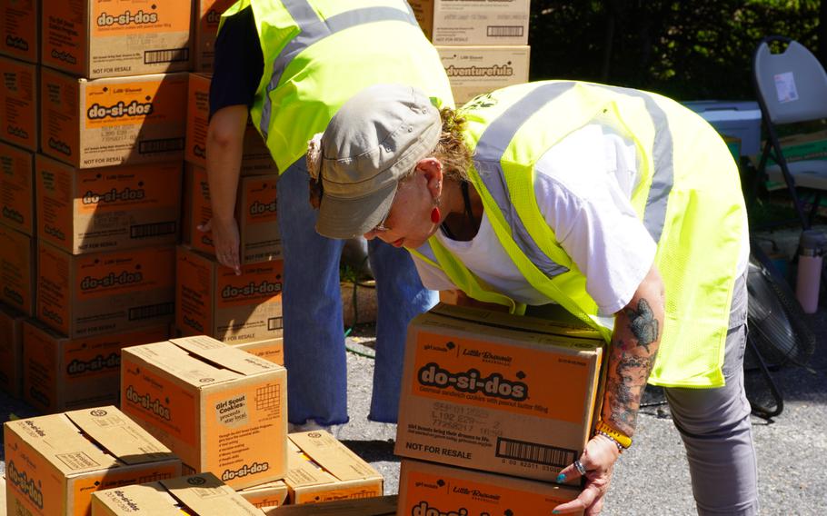 A woman lifts a box.