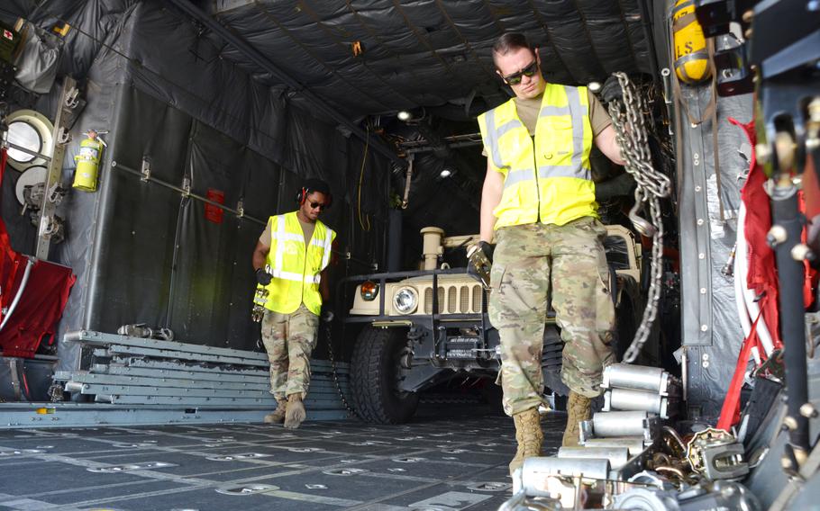 Airmen unchain a Humvee before offloading it from a C-130H as they reconfigure the aircraft for the next team in the 721st Aerial Port Squadron Multi-Capable Airmen Rodeo at Ramstein Air Base, July 23, 2021. Teams of airmen had to load the aircraft safely within 20 minutes in a simulated engine running exercise. 