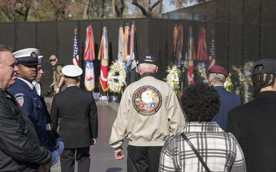Retired Army Lt. Col. Hank Cramer, center wearing tan jacket, walks to the Vietnam Veterans Memorial wall on Wednesday, March 29, 2023, in Washington, D.C., where a silent wreath laying ceremony was held in honor of National Vietnam War Veterans Day. 
