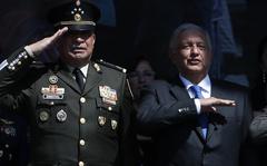 FILE - Defense Secretary Luis Cresencio Sandoval, left, and Mexican President Andres Manuel Lopez Obrador salute during an event marking Army Day at the Zocalo in Mexico City, Feb. 19, 2020. According to seizure figures issued Monday, Dec. 20, 2021, Mexican drug cartels are turning to bigger, more productive labs to churn out increasing quantities of synthetic drugs like meth and fentanyl. Defense Secretary Luis Cresencio Sandoval acknowledged there has been a huge shift by Mexican cartels away from naturally grown drugs like opium and marijuana, where seizures and crop eradication has fallen.  (AP Photo/Marco Ugarte, File)