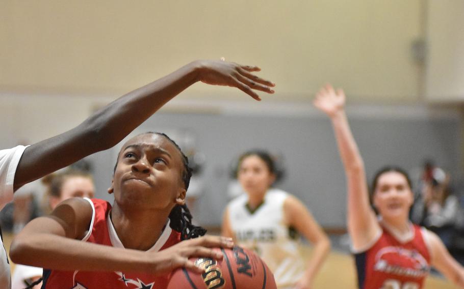 Aviano's Lania Burkes ignores an arm in her face to look toward the basket in the Saints' 35-20 loss to Naples on Saturday, Jan. 7, 2023.