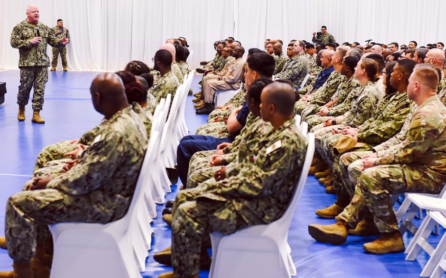 Honea speaks to a group of seated sailors and Marines.