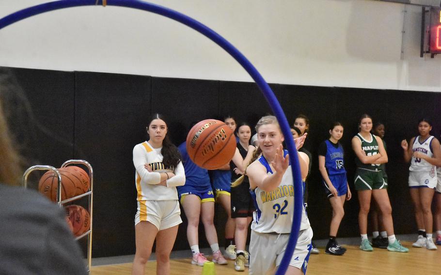 Gwen Icanberry di Wiesbaden inizia la competizione di abilità mentre la compagna di squadra Mia Snyder di Stoccarda e altri guardano sabato 24 febbraio 2024, durante la partita di basket DODEA-Europe Girls All-Star a Vicenza, Italia.