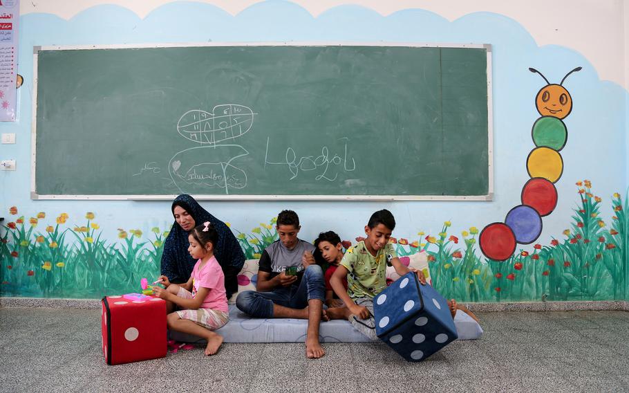 Kowkab Hassanian plays with her children in a school where they took shelter after their house was destroyed in Gaza City. 