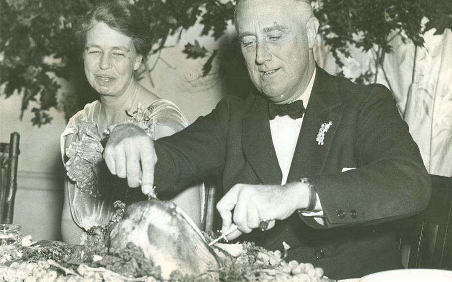 First lady Eleanor Roosevelt watches as President Franklin D. Roosevelt operates on the big turkey, setting in motion the annual Thanksgiving feast at Warm Springs, Ga., on Nov. 29, 1935.