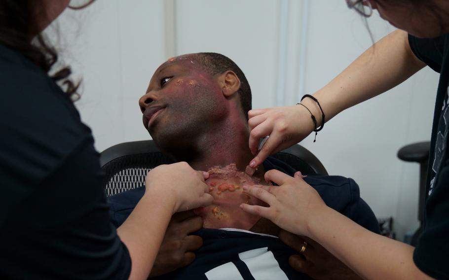 Makeup is applied to an actor taking part in mass casualty training at Yokosuka Naval Base, Japan, Wednesday, May 17, 2023.