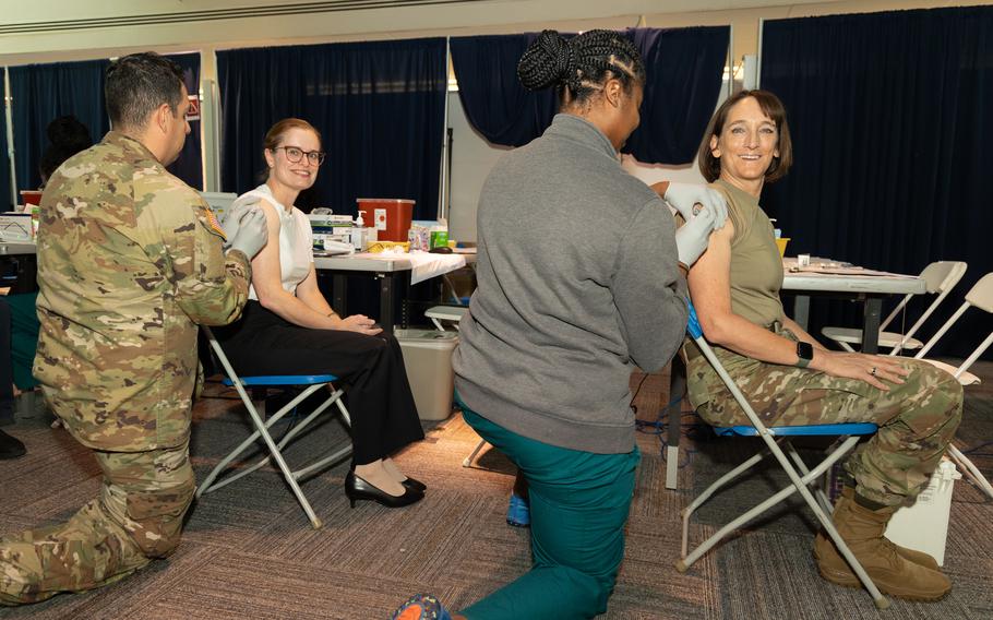 Army Brig. Gen. Deydre Teyhen, right, and Navy Capt. Melissa Austin receive a COVID-19 shot Oct. 10, 2023, at Walter Reed National Military Medical Center in Maryland. The latest COVID-19 shots are just now arriving for service members, Defense Department civilians and their families at some locations in Europe.