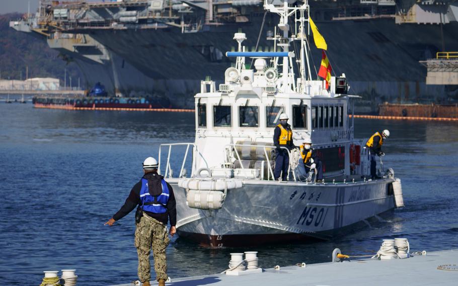 Teams aboard a Japan Coast Guard vessel collect water samples near the USS Ronald Reagan during an annual drill that simulates a radiation leak from the aircraft carrier, Wednesday, Dec. 15, 2021.