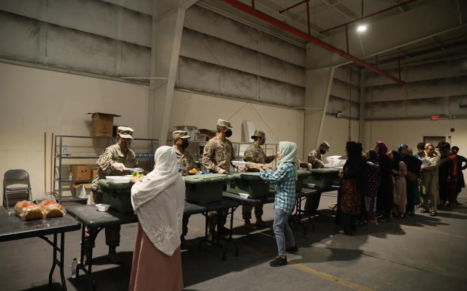 U.S. Army Soldiers serve a lunch meal to Afghan Special Immigrants at a dining facility Tuesday. Soldiers assigned to the facility, prepare and serve meals to Afghan Special Immigrants while they complete Special Immigrant Applications.