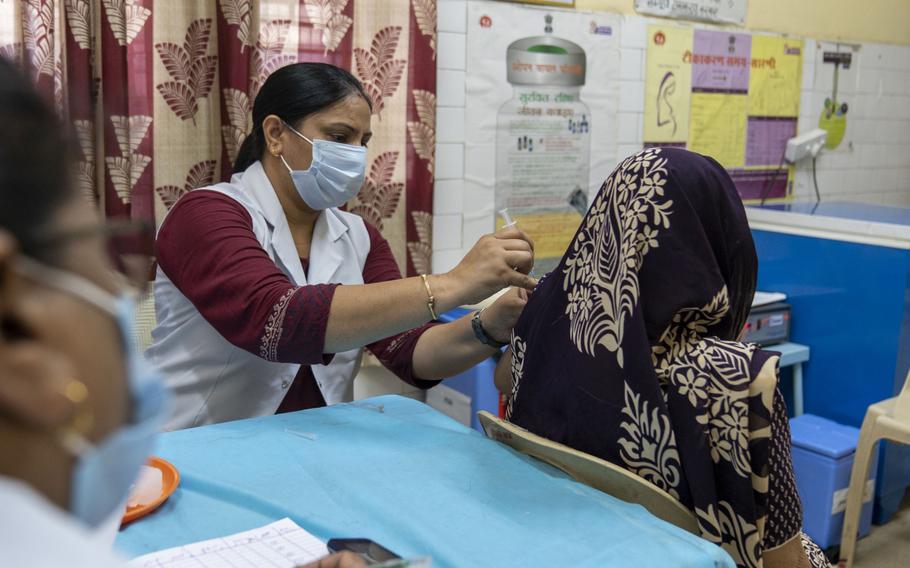 A health worker administers a dose of the Bharat Biotech Covaxin vaccine in the Daryagunj area of New Delhi on June 21, 2021. 