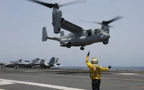 FILE -In this image provided by the U.S. Navy, Aviation Boatswain's Mate 2nd Class Nicholas Hawkins, signals an MV-22 Osprey to land on the flight deck of the USS Abraham Lincoln in the Arabian Sea on May 17, 2019. When the U.S. military took the extraordinary step of grounding its fleet of V-22 Ospreys this week, it wasn't reacting just to the recent deadly crash of the aircraft off the coast of Japan. The aircraft has had a long list of problems in its short history. (Mass Communication Specialist 3rd Class Amber Smalley/U.S. Navy via AP)