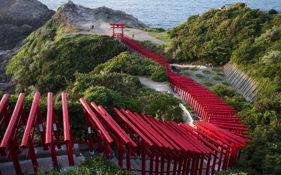 Stroll on a path beneath 123 torii gates toward picturesque sea views during a visit to Motonosumi Inari Shrine in Yamaguchi prefecture, Japan.