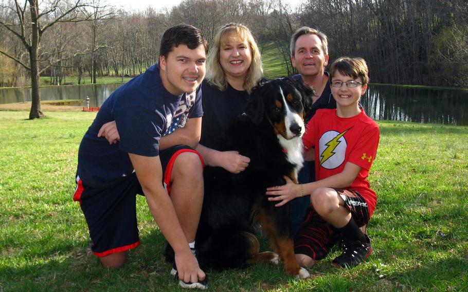 Andrew and Cathy Hakun pose with their and sons Steven, left, and Patrick, and their dog, Wooffulls, in Woodbine, Md., Aug. 8, 2017.