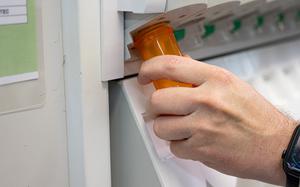A hand fills a prescription.