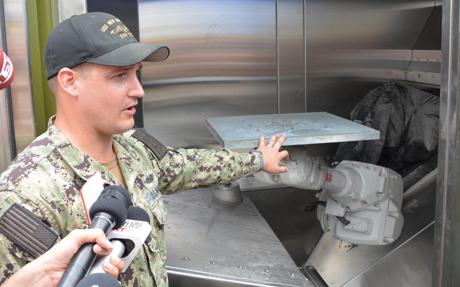 Navy Lt. Joel Hunter shows reporters a 3D printer being used in the Rim of the Pacific exercise to manufacture metal parts during a demonstration at Marine Corps Base Hawaii on July 2, 2024.