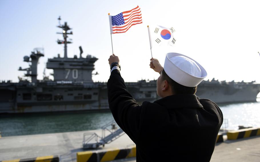 A South Korean sailor welcomes the aircraft carrier USS Carl Vinson to Busan, South Korea, in 2017. 