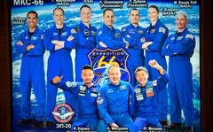 An image of the members of ISS-66 crew is seen on a monitor in Mission Control Center in Korolyov, outside Moscow, early on Dec. 20, 2021.