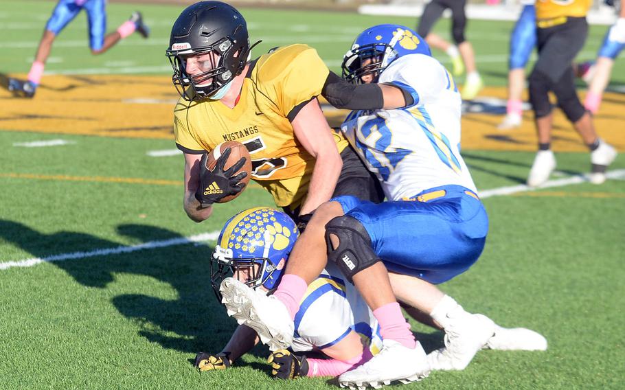 American School In Japan's Pierce Smith gets hauled down by Yokota's Braedan Raybon and Caleb Jones. A personal foul for a horse collar tackle was called on the play.