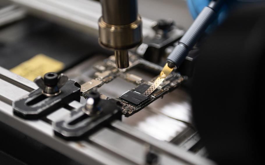 A specialist removes the SMIC chip from a Huawei Mate 60 Pro smartphone in Ottawa, Canada, on Sept. 3. 