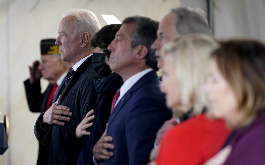 President Joe Biden stands as a rendition of the national anthem is performed during a Memorial Day event at Veterans Memorial Park at the Delaware Memorial Bridge in New Castle, Del., Sunday, May 30, 2021.