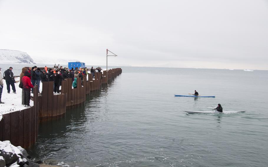 A few dozen spectators watch two Inuit men demonstrate how they use kayaks for fishing and hunting. The pair rolled their kayaks for about 20 minutes in the icy waters before joining the crowd for some restorative narwhal soup and seal stew.