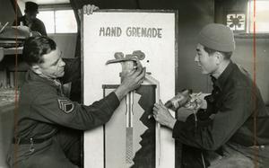 Hed: Just don't drop the real thing, 1961

Yongsan Garrison, South Korea, December 1961:    Chi Jung Kim (right), carpenter shop supervisor and S/Sgt. Dell E. Carter, non-commissioned officer in charge at the Eight Army Training Aids Center finish the build of a grenade mock-up, showing the inside workings of a hand grenade.  

The center provides any equipment or device needed as training aid for military classes throughout the United Nations Command. Most of the items – anything from lecterns and pointers to hurdles for sentry dog training and even a fake human arm with “blood” for medic training - are stocked in the Yongsan warehouse. 

Regular shipments from the Naval Training Devices Center and the Department of the Army take care of some of the supplies, but many of the items – such as the fake arm – are constructed by local Korean members of the center themselves. The unit is run by two officers, and they are the only military personnel in the outfit.

Pictured here is a scan of the original 1961 print created by Stars and Stripes Pacific's photo department to run in the print newspaper. The red marks indicate the crop lines. Only the middle part of the image would appear in the newspaper. 

As the vast majority of pre-1964 Stars and Stripes Pacific negatives and slides were unwittingly destroyed by poor temporary storage in 1963, the prints developed from the late 1940s through 1963 are the only images left of Stripes' news photography from those decades – with the exception the negatives of some 190 pre-1964 photo assignment found recently. 

Stars and Stripes' archives team is scanning these prints and negatives to ensure their preservation.
 
META TAGS:  U.S. Army; servicemember; military supplies; logistics; South Korean; locals; Yongsan Garrison