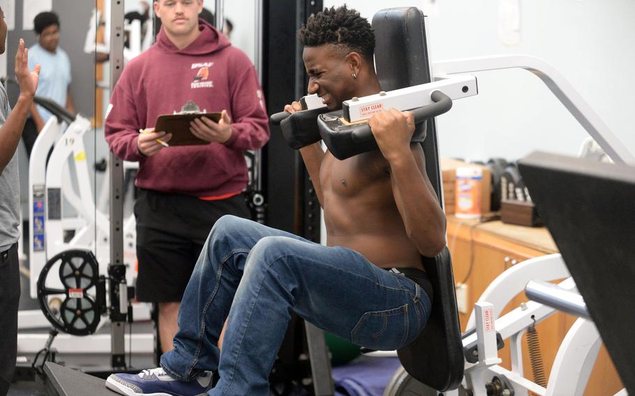 Freshman Justiss Parker-Jones grits his teeth doing squats under the watchful eye of assistant coach Jason Callison.