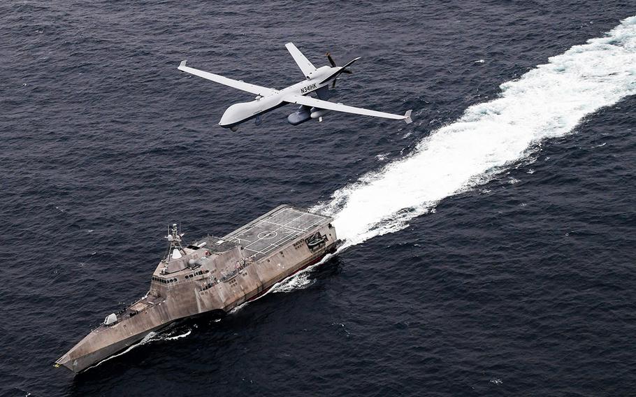 An MQ-9 SeaGuardian unmanned maritime surveillance system flies over the littoral combat ship USS Coronado in the Pacific Ocean, April 21, 2021.