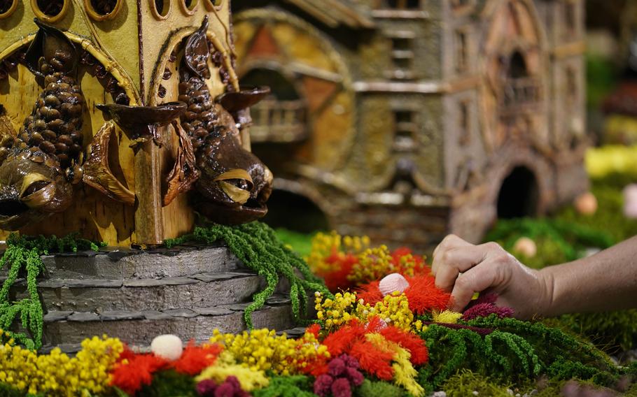 Stephanie Winters fills in the landscaping around a Coney Island themed display as part of the preparations for the annual Holiday Train Show at the New York Botanical Garden in New York, Thursday, Nov. 11, 2021. The show, which opens to the public next weekend, features model trains running through and around New York landmarks, recreated in miniature with natural materials. 