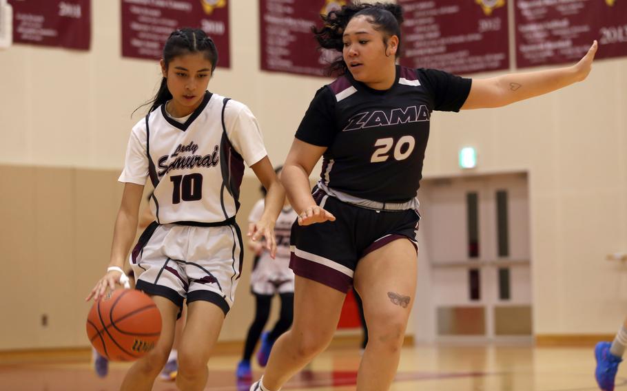 Matthew C. Perry's Aiana Bulan dribbles against Zama's Deborah McClendon during Friday's DODEA-Japan girls basketball game. The Trojans won 39-31.