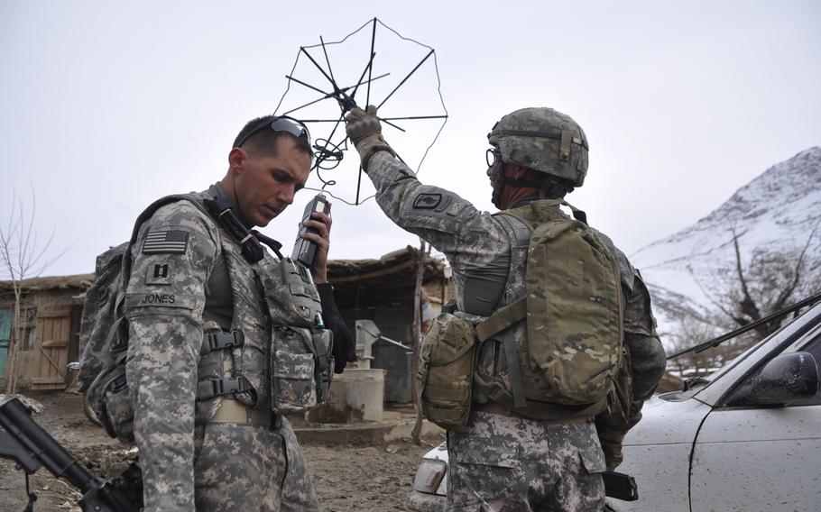 Capt. Kirby Jones, left, and Spc. David Robertson, set up radio communications during a patrol of a village in Wardak province.