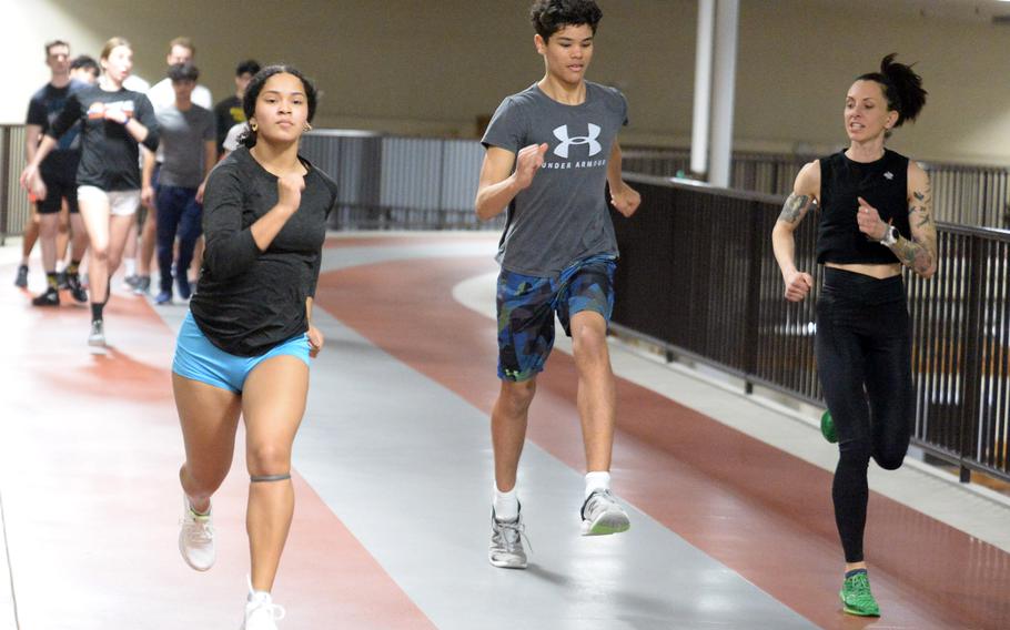 Senior Zalea Washington, last year's Far East Division I virtual long jump champion runs alongside freshman hurdler Noah Medonis and Robert D. Edgren assistant coach Amanda Tungett.