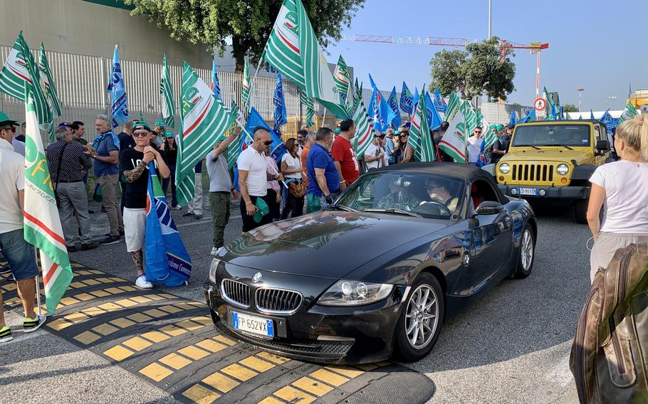 Cars trying to enter Naval Support Activity Naples slowly roll by a crowd of Italian base workers on strike on June 30, 2023. While the strike snarled morning rush hour traffic, it did not significantly impact base services.