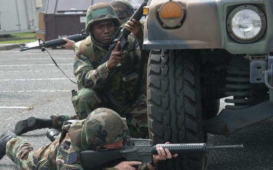 Yokota Air Base, Japan, Aug. 1, 2006: Staff Sgt. Edwin Mena of the 374th Logistics Readiness Squadron pulls security beside a Humvee with other airmen while learning convoy-ambush survival tactics Tuesday at Yokota Air Base, Japan. Sponsored by Pacific Air Forces, it's conducted by retired military members from an organization called Advancing National Strategies and Enabling Results, or ANSER. 

META TAGS: U.S. Air Force; training; exercise; 