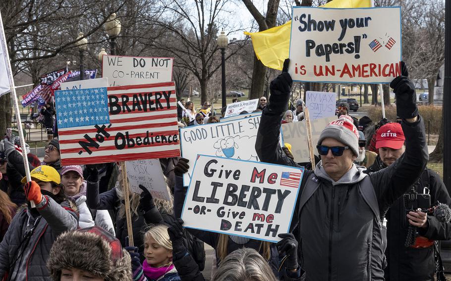 Participants in a rally in opposition to vaccine mandates march past the National World War II Memorial on their way to the Lincoln Memorial in Washington, D.C., Jan. 23, 2022.