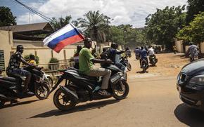 Supporters of Capt. Ibrahim Traore wave a Russian flag in the streets of Ouagadougou, Burkina Faso, Oct. 2, 2022. 